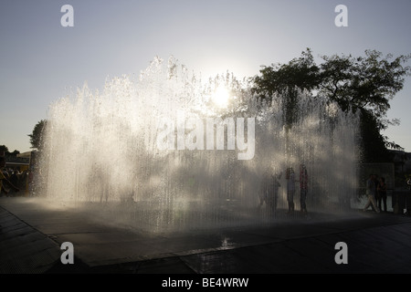 Fontana urbano con interazione pubblica,South Bank di Londra,uk .sagome contro il tardo pomeriggio di sole estivo Foto Stock