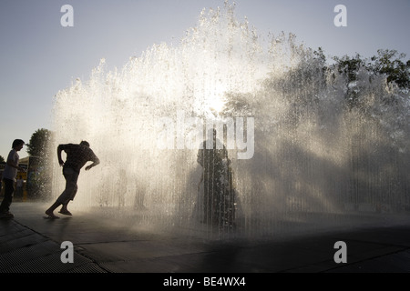 Fontana urbano con interazione pubblica,South Bank di Londra,uk .sagome contro il tardo pomeriggio di sole estivo Foto Stock