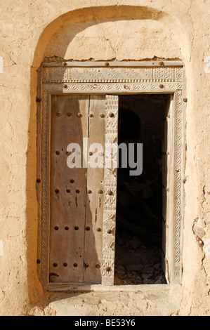 Legno intagliato nella porta della storica fortificazione adobe Jaalan Bani Bu Ali Fort o castello, Sharqiya regione, il sultanato di Oman, un Foto Stock