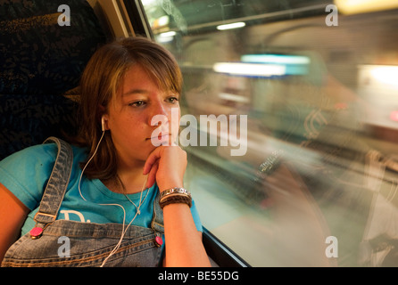 Ragazza seduta da sola in un treno, guardando fuori della finestra, Germania Foto Stock