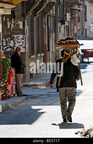 Uomo che porta in legno tabella vendite con simit sulla sua spalla, vendita simit, il vecchio quartiere ebraico di Balat, Istanbul, Turchia Foto Stock