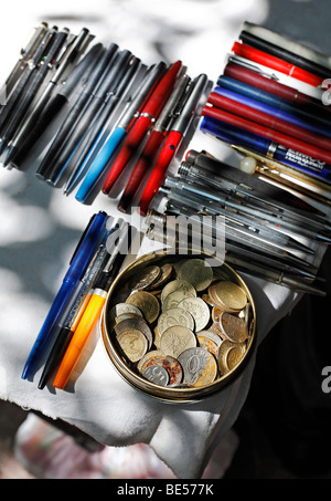 Barattolo di latta con le vecchie monete turco e biros utilizzato su una tavola di un venditore ambulante, prenota bazaar, Beyazit Square, Istanbul, Turchia Foto Stock