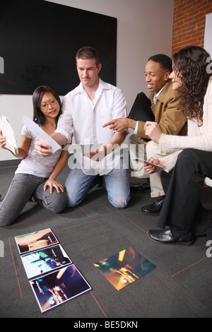 Un gruppo di giovani creativi business persone guardano artwork Foto Stock