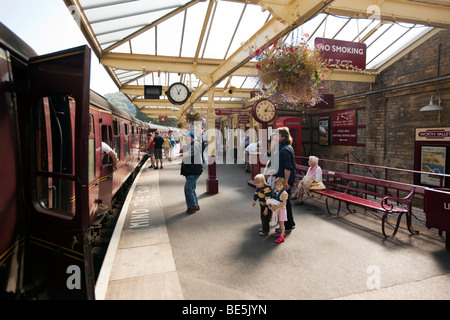 Regno Unito, Inghilterra, Yorkshire, Keighley stazione ferroviaria, Keighley e vale la pena di Valley Steam Railway Station ai passeggeri di salire a bordo treno Foto Stock