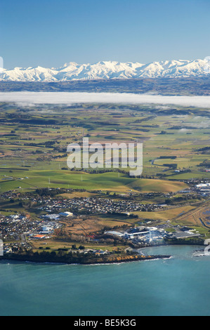 Smithfield opere di congelamento (a destra), Timaru, e neve sulle Alpi del sud, Canterbury sud, South Island, in Nuova Zelanda - aerial Foto Stock