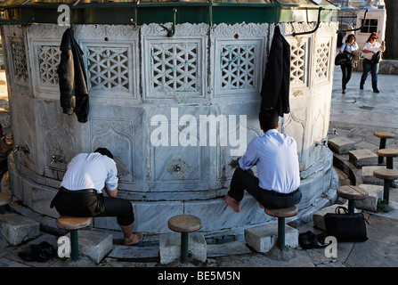 Due uomini musulmani in business vestiti lavare i loro piedi in un purgation bene, Sadirvan, Iskele, Mirimah la Moschea del Sultano, Ueskuedar, IST Foto Stock