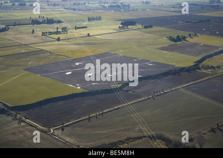 Le linee di alimentazione attraverso i terreni agricoli vicino a Timaru, Canterbury sud, South Island, in Nuova Zelanda - aerial Foto Stock