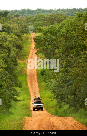 Land Cruiser guidando lungo una strada sterrata in Murchison Falls National Park, Uganda. Foto Stock