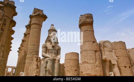 Tempio di Luxor complessa, statua di Ramses II nel primo cortile tra due massicce colonne, Tempio di Luxor, Egitto, Africa Foto Stock