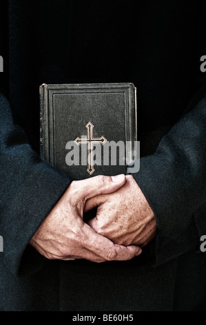 Sacerdote con la Bibbia in mano Foto Stock