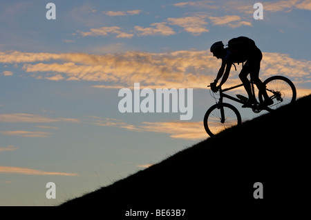 Mountainbiker, silhouette al monte Hohe Salve nella luce della sera, Tirolo, Austria, Europa Foto Stock