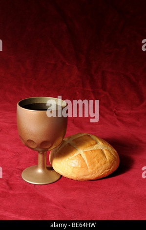 La comunione gli elementi rappresentati da pane e vino su uno sfondo rosso Foto Stock