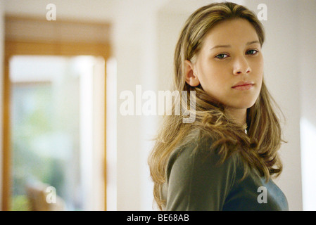 Ragazza adolescente guardando sopra la spalla, ritratto Foto Stock