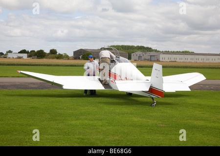 Uno "Jodel" D112 G-BVEH parcheggiato a Breighton Airfield con piloti riguardo alla scheda Foto Stock