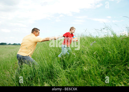 Padre e figlio giocando su un prato Foto Stock