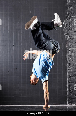 Giovane uomo danza moderna. Sulla parete scuro dello sfondo. Foto Stock