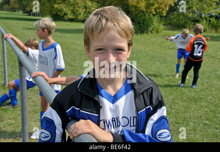 Un nove-anno-vecchio giocatore dell'E-2 junior league in attesa per il match di avviare, per bambini torneo di calcio, Baden-Wuerttember Foto Stock