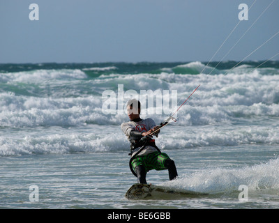 Kitesurfer accelerando attraverso le onde a Les Pieux, Normandia, Francia Foto Stock