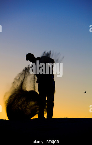 Silhouette di un golfista a fine giornata Foto Stock