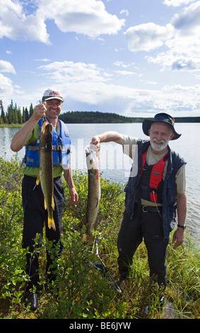 Due pescatori presentando le loro catture, luccio del nord, Jack, Jackfish (Esox lucius), Caribou Coffee Company laghi, superiore Liard River, Yukon Terr Foto Stock