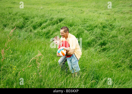 Padre e figlio giocando su un prato Foto Stock