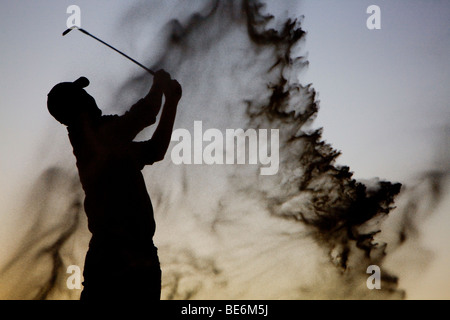 Silhouette di un golfista a fine giornata Foto Stock