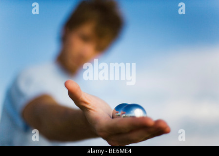 Uomo con yin yang palle in mano, close-up Foto Stock