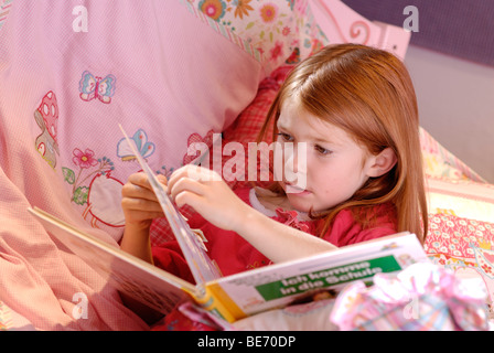 Bambina la lettura di un libro di fotografia Foto Stock