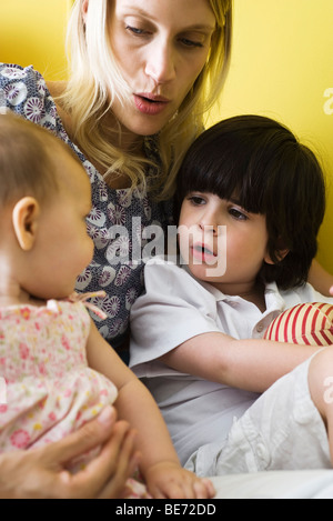 Azienda madre figlia infante e figlio sul giro, close-up Foto Stock