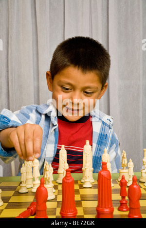 7-8 anni ragazzo ispanica di imparare a giocare a scacchi. Signor © Myrleen Pearson Foto Stock
