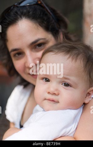 Madre ispanica nei suoi anni trenta tiene i suoi sei mesi baby boy. Modello rilasciato Foto Stock