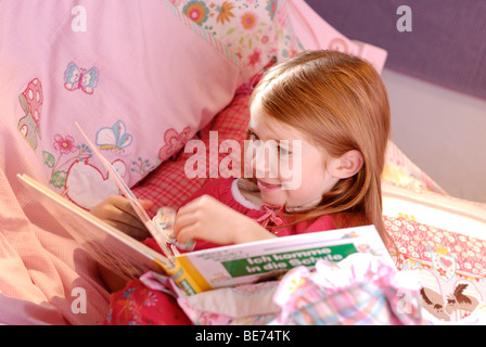 Bambina la lettura di un libro di fotografia Foto Stock