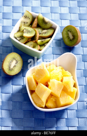 Fette di kiwi e ananas in ciotole Foto Stock