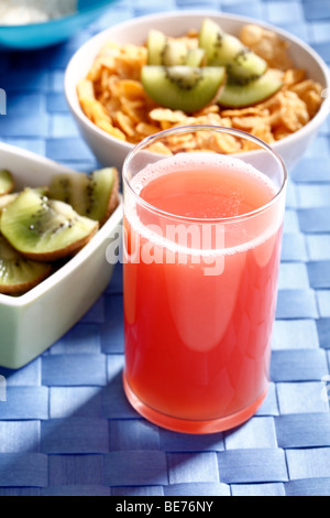 La colazione, succhi di frutta, corn flakes e fette di kiwi Foto Stock