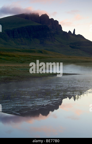 Acqua calma riflettendo il vecchio uomo di Storr rock formazione a distanza, Isola di Skye in Scozia Foto Stock