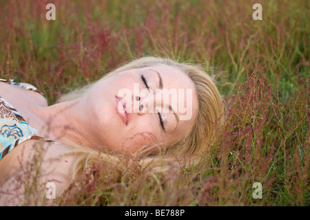 Giovane donna bionda di dormire su un prato Foto Stock