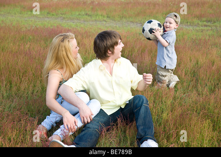 Coppia giovane e figlio giocando su un prato Foto Stock