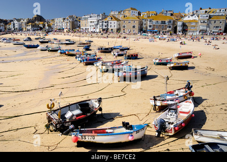 Barche da pesca spiaggiata sulla sabbia in un porto a bassa marea Foto Stock