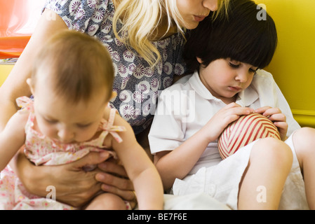 Azienda madre figlio e figlia infante sul giro, boy broncio, ritagliato Foto Stock