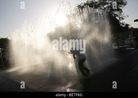 Fontana urbano con interazione pubblica,South Bank di Londra,uk .sagome contro il tardo pomeriggio di sole estivo Foto Stock