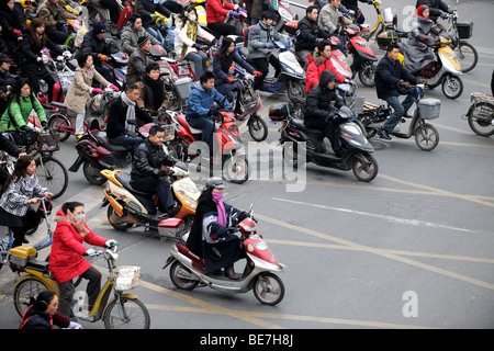 Folla sulle motociclette e biciclette di attraversare in Cina a Shanghai Foto Stock