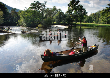 Pomeriggio estivo una famiglia paddling in due open kayak vicino a ferro di cavallo cade sul fiume Dee, vicino a Llangollen, Wales UK Foto Stock