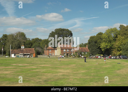 Lurgashall verde villaggio vede una partita di cricket su un caldo e soleggiato giorno d'autunno. Foto Stock