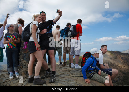 Escursionisti fotografati sulla cima di Snowdon, Snowdonia National Park (Eryri), Gwynedd, Galles Foto Stock