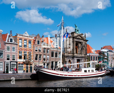 Barca ormeggiata sul fiume Spaarne e case storiche in Haarlem Paesi Bassi Foto Stock