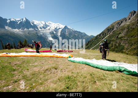 I piloti di parapendio preparare per decollare da Brevent, nella valle di Chamonix di fronte al massiccio del Monte Bianco, Francia. Foto Stock