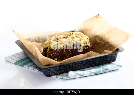 Polpettone con formaggio cotto su carta da forno in una teglia da forno Foto Stock