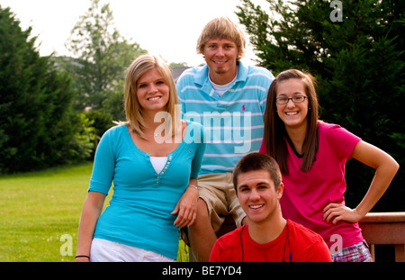 Moderno e gli adolescenti di età compresa tra 14 a 18 appendere fuori a casa insieme come amici al di fuori in giardino Foto Stock