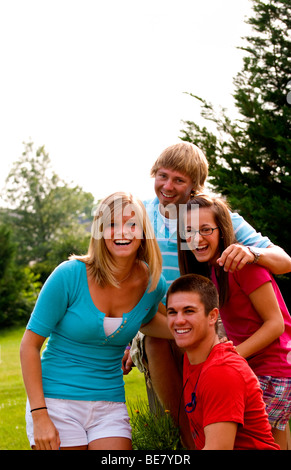 Moderno e gli adolescenti di età compresa tra 14 a 18 appendere fuori a casa insieme come amici al di fuori in giardino Foto Stock