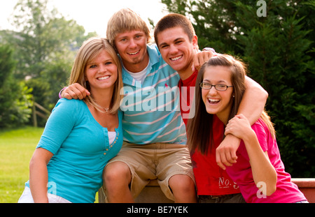 Moderno e gli adolescenti di età compresa tra 14 a 18 appendere fuori a casa insieme come amici al di fuori in giardino Foto Stock